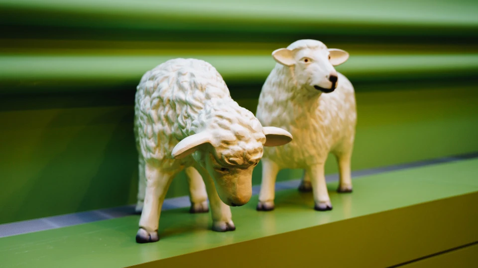 Zwei dekorative Schaf-Figuren auf einem grünen Sideboard in einem modern gestalteten Konferenzraum