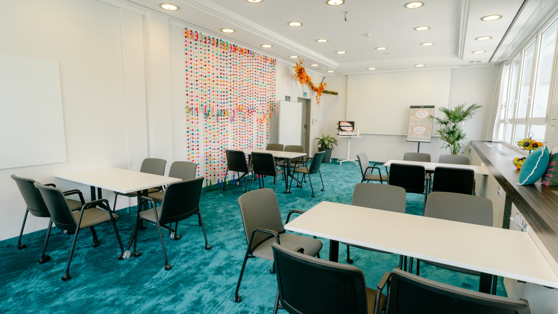 Ein heller, modern gestalteter Besprechungsraum mit verspielter Wanddekoration und inspirierender Atmosphäre