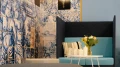 Gemütliche Lounge-Ecke mit hoher Sitzbank, Kissen und Blumen, umgeben von kunstvollen blauen Fliesen