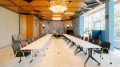 Eleganter Konferenzraum mit U-förmiger Tischanordnung, goldener Decke und kunstvollen Wandfliesen