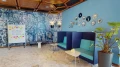 Gemütliche Meeting-Ecke mit blauen Sitznischen, dekorativen Tellern und kreativer Ideenwand