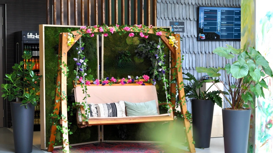 Schaukelbank mit Blumenranken, Pflanzen und gemütlicher Atmosphäre im Innenbereich